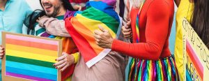 Photo of individuals wearing bright colors and rainbow pride flags smiling. Are you a part of the LGBTQ community? Learn how to provide support for the lgbtq community in Gallatin, TN. 