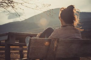 Photo of a woman sitting outside on a bench. Are you struggling with holiday anxiety in Gallatin, TN? Learn tips on managing your holiday anxiety and be stress free.