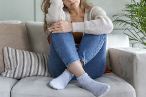 Photo of a woman sitting on the couch with her hand on her head worried about her depression. This photo represents how depression treatment in Gallatin, TN can help you begin healing your brain and managing your depression symptoms. Click here to learn more.