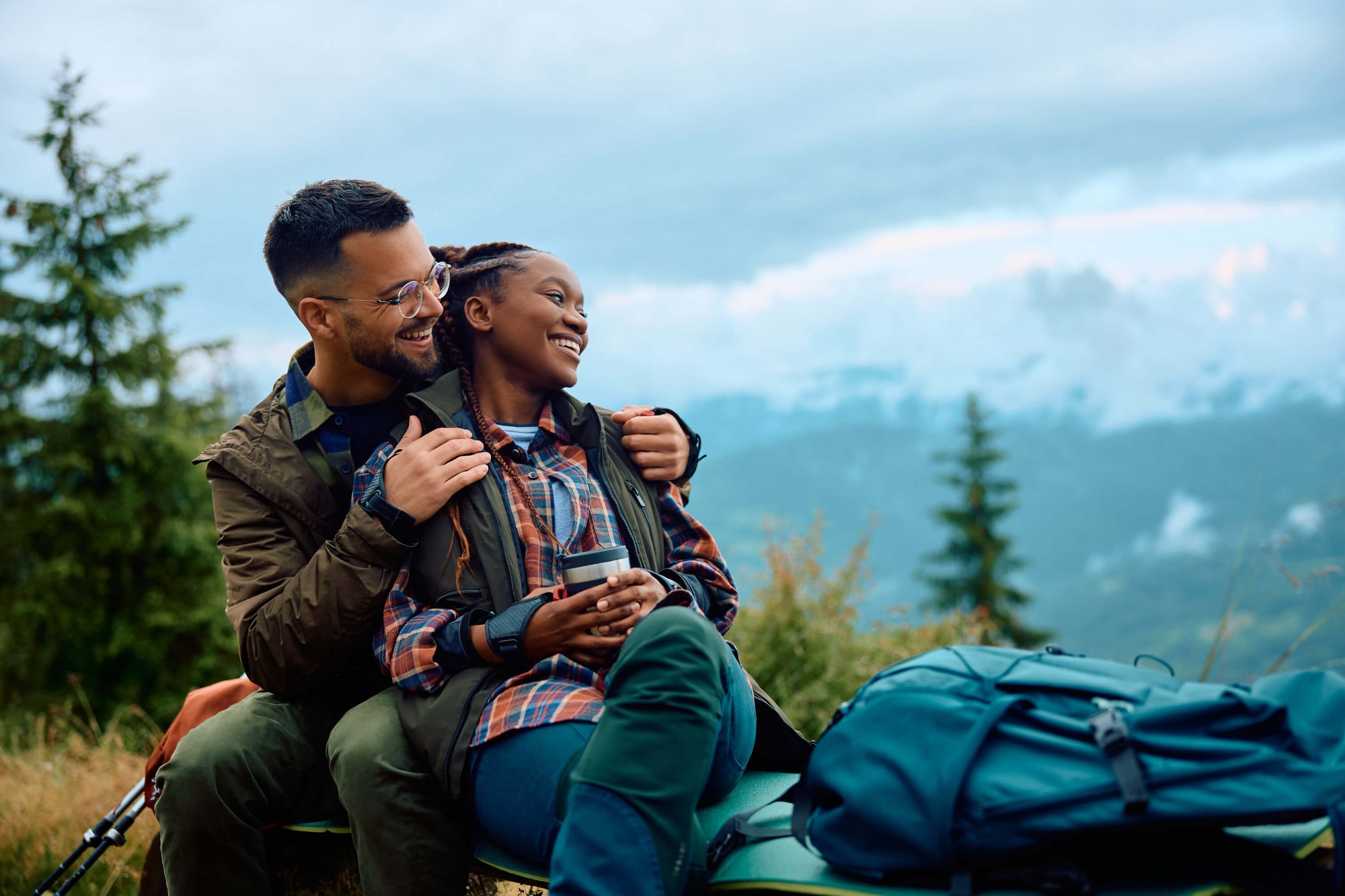 TN-Mental-Wellness-Couples-Therapy-black-man-and-lady-smiling-sitting-together-outside-in-forest