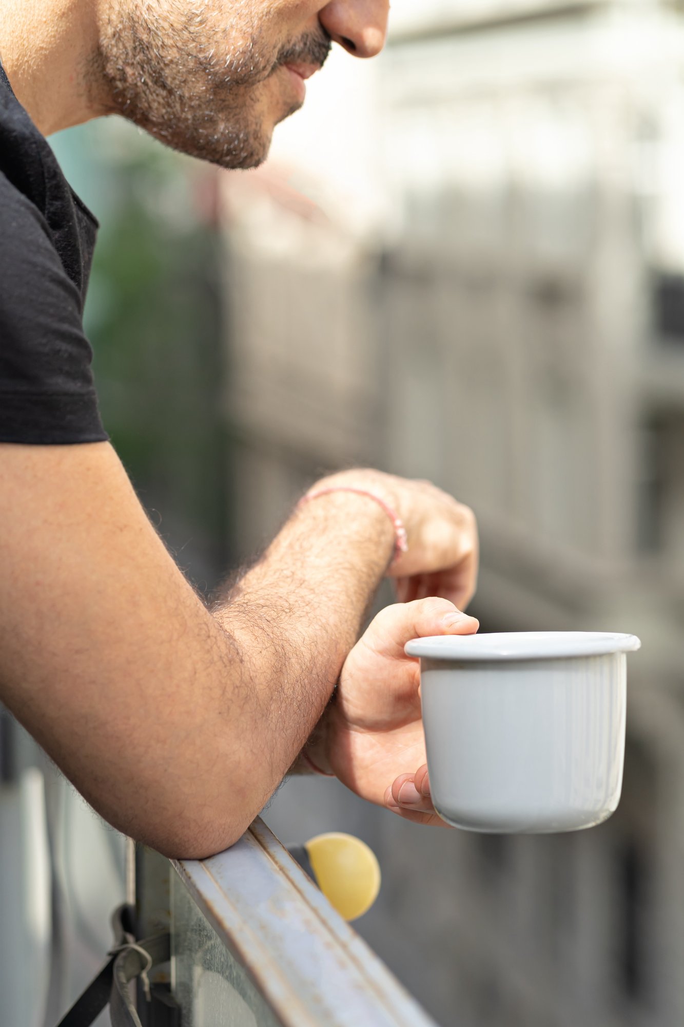 man-trauma-holding-coffee-or-tea-cup-standing-on-balcony-2024-11-25-12-35-48-utc